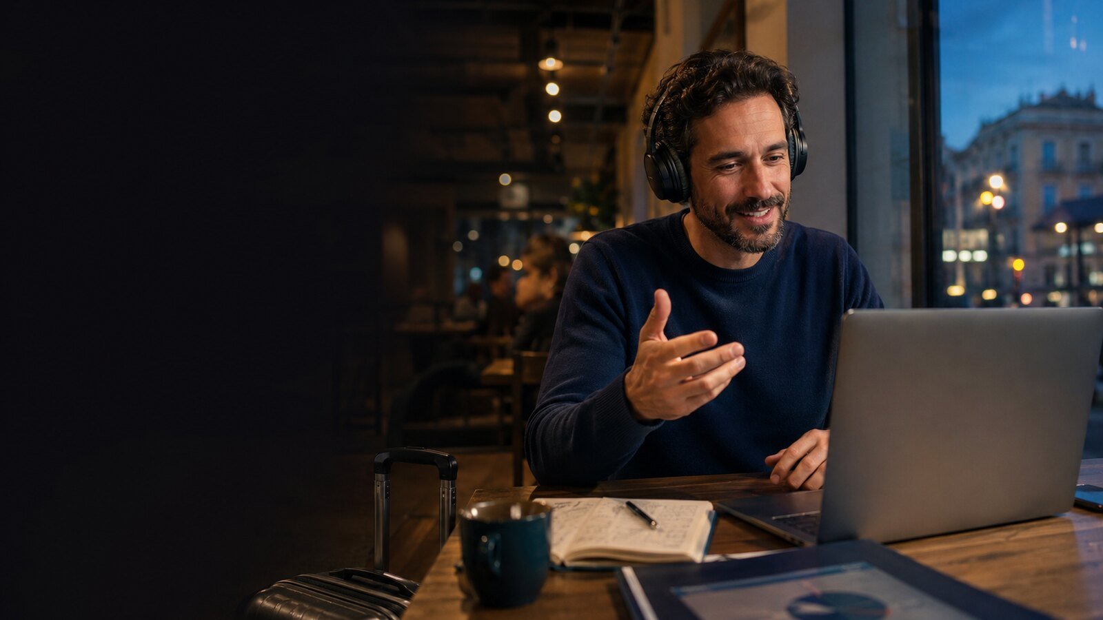Hombre adulto practicando inglés con auriculares y un portátil en una cafetería luminosa